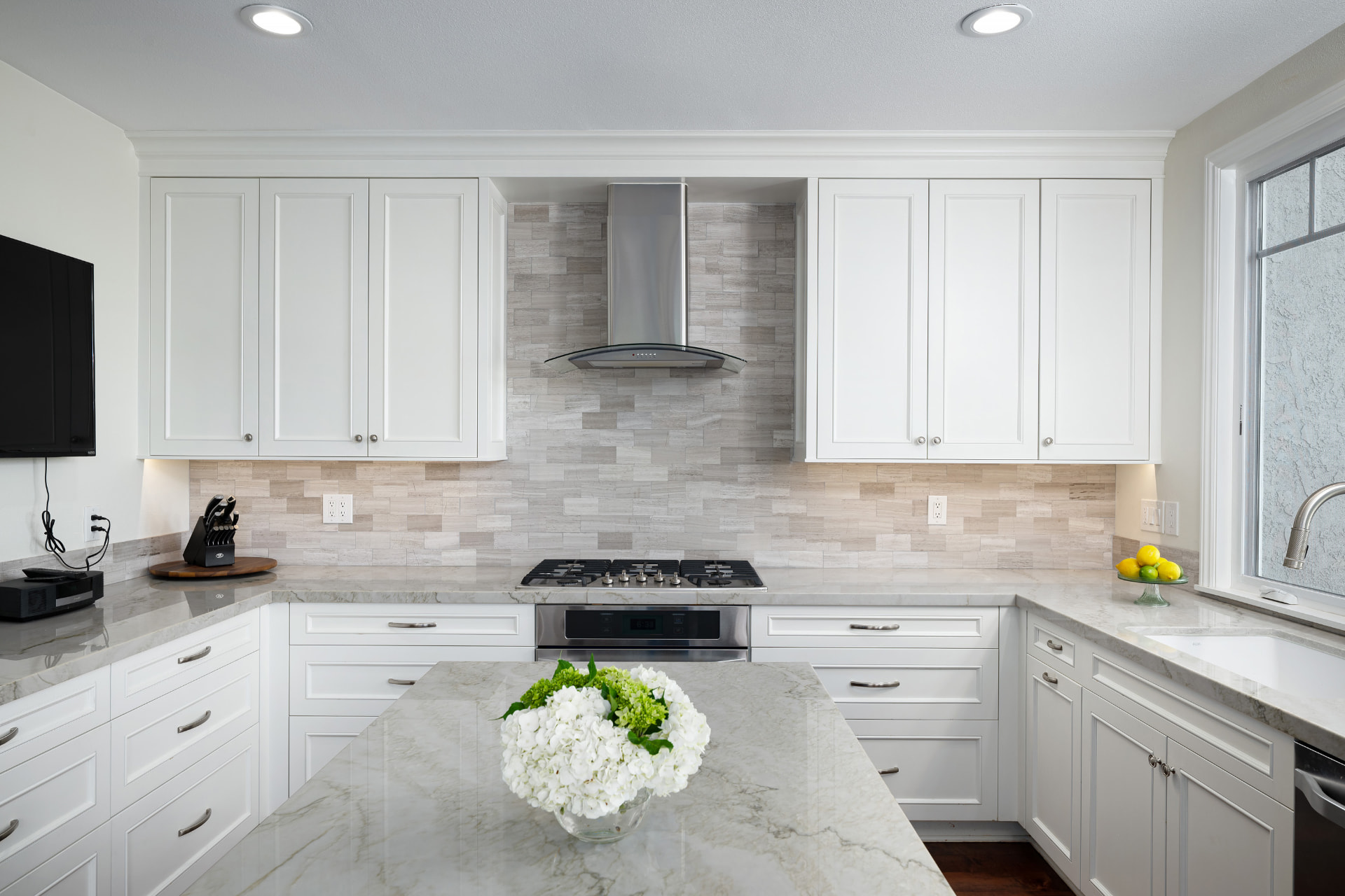 Kitchen range wall with stone backsplash and white cabinetry