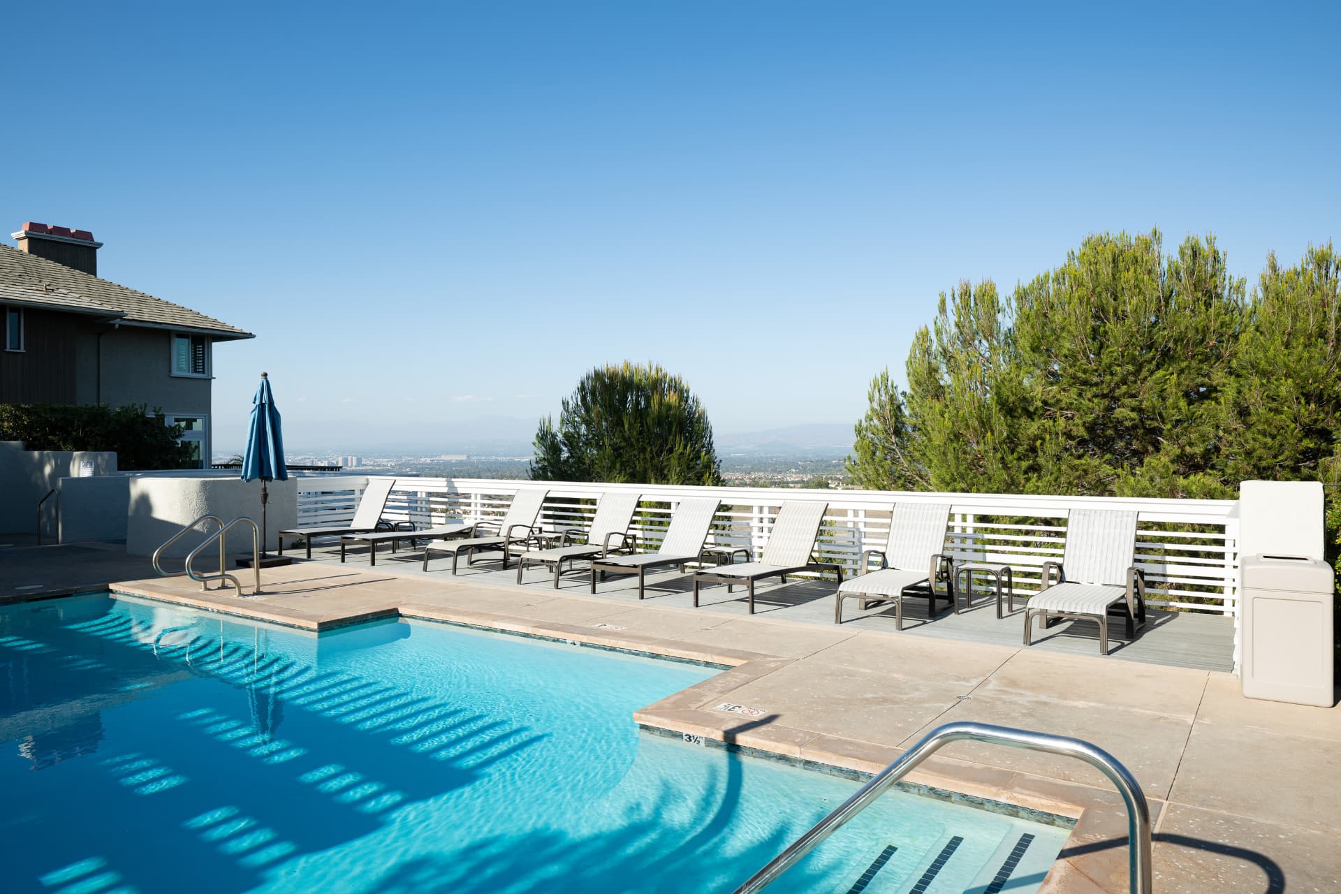Community pool with lounge chairs overlooking the city lights