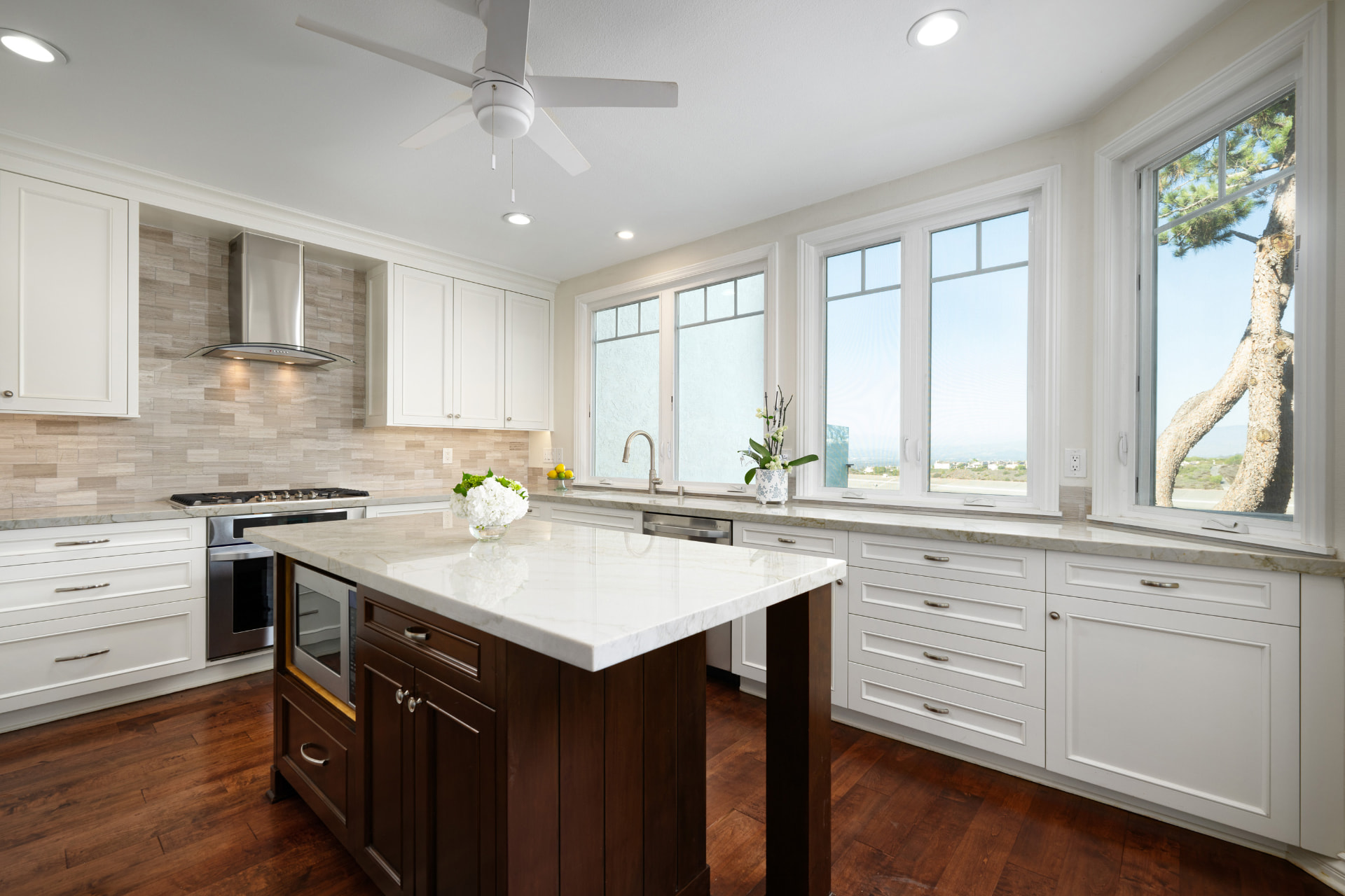 Remodeled kitchen with island, marble counters, and garden windows