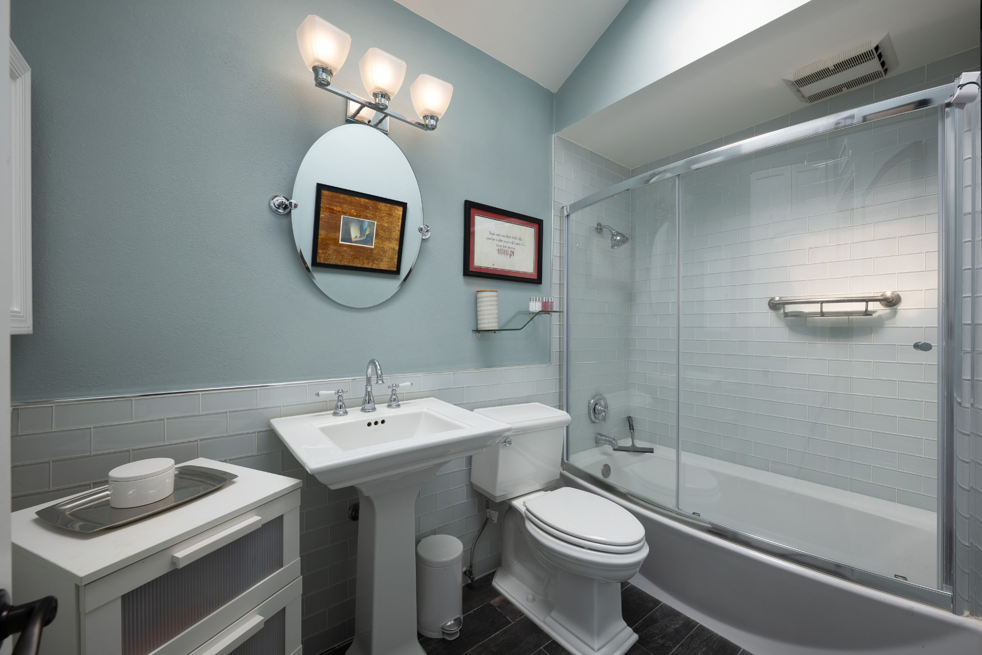 Guest bath with pedestal sink and glass-tile walk-in shower
