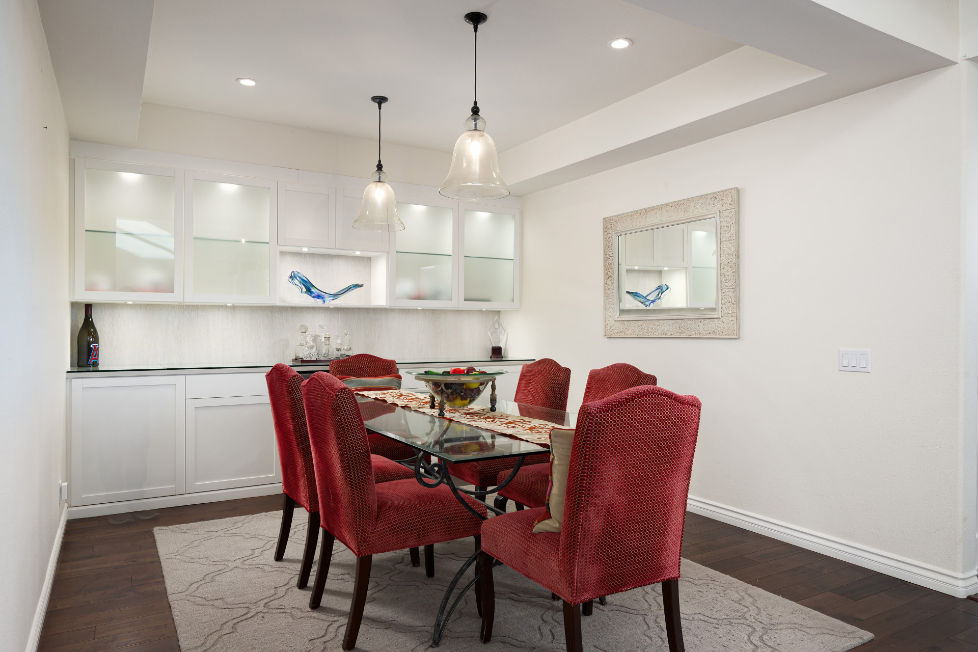 Formal dining room with red upholstered chairs and built-in buffet